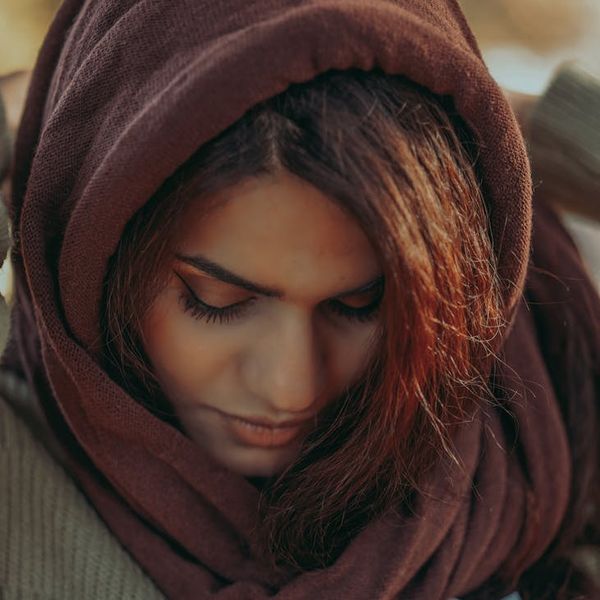 Person meditating outdoors with a calm and focused expression.